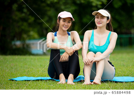 Two beautiful Asian teenage sitting and looking at camera together 65884498