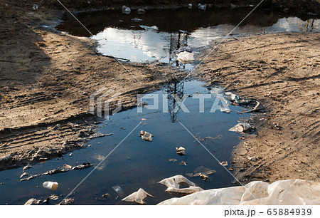 Garbage in the mud on the dirt road. Garbage in the mud on the dirt road. 65884939