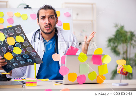 Young male medic in conflicting priorities concept 65885642