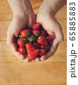 A handful of red, fresh strawberries in male hands 65885883