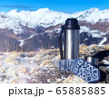 Hiking still life with a metal thermos on top of a mountain and in the background 65885885