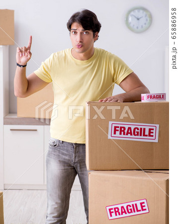 Man moving house and relocating with fragile items Man moving house and relocating with fragile items 65886958