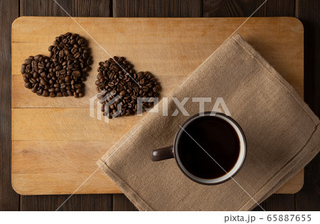 A heart of coffee beans on a wooden background 65887655