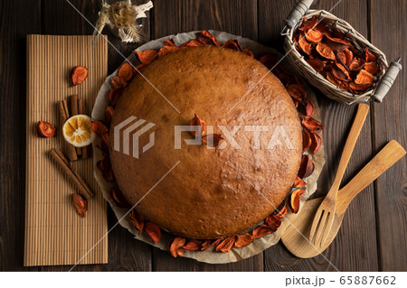 Homemade cake decorated with dried flower petals on parchment paper 65887662