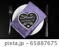 Black heart made of wood on a white plate with Cutlery on the sides 65887675