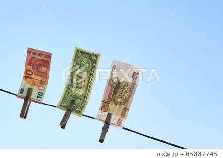 Banknotes of different countries hang on a rope against the blue sky Banknotes of different countries hang on a rope against the blue sky 65887745