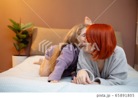 Happy mother and her baby daughter girl on bed in bedroom. Happy mother and her baby daughter girl on bed in bedroom. 65891805