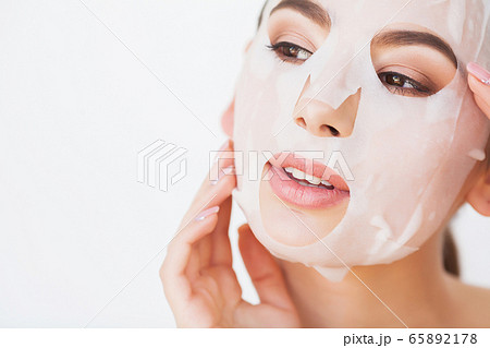 Spa Woman applying Facial cleansing Mask. Beauty Treatments 65892178