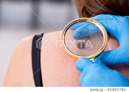 Young woman visiting male doctor dermatologist 65892783
