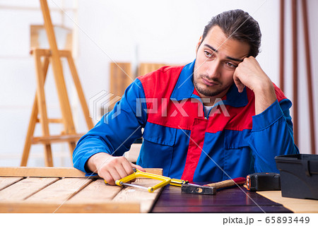 Young male contractor working in workshop Young male contractor working in workshop 65893449