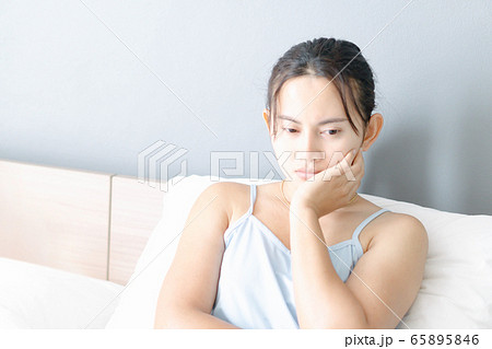 Closeup woman sitting on bed in the bedroom with Closeup woman sitting on bed in the bedroom with 65895846