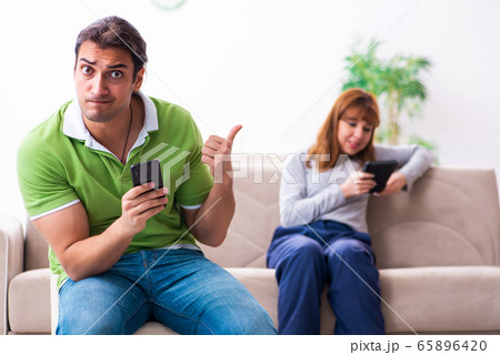 Young couple in gadget dependency concept Young couple in gadget dependency concept 65896420
