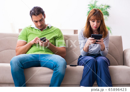 Young couple in gadget dependency concept Young couple in gadget dependency concept 65896423