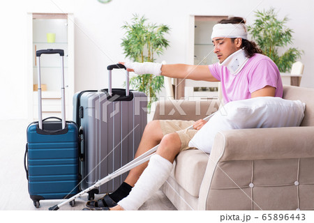 Young injured man preparing for the trip Young injured man preparing for the trip 65896443