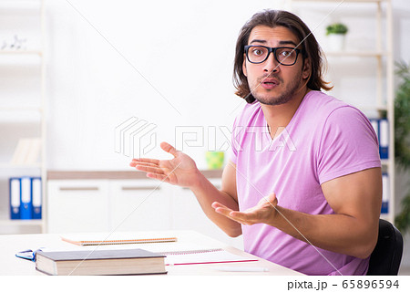 Young male student preparing for exams at classroom Young male student preparing for exams at classroom 65896594