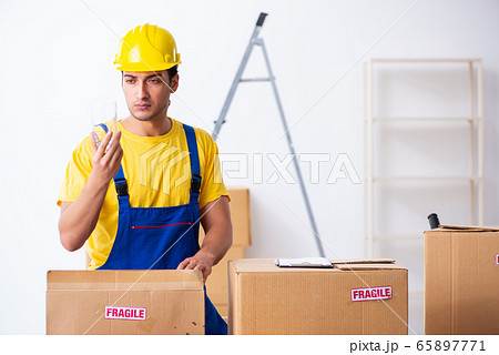 Young male professional mover doing home relocation Young male professional mover doing home relocation 65897771