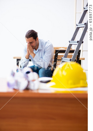 Young male architect working indoors 65897773