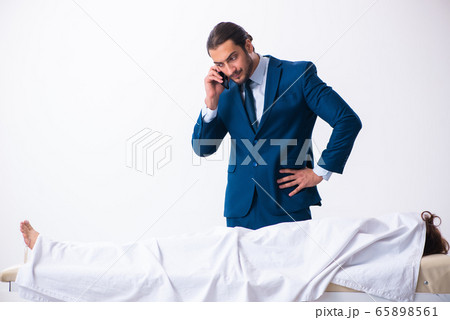 Police coroner examining dead body corpse in morgue Police coroner examining dead body corpse in morgue 65898561