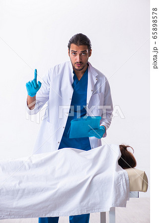 Police coroner examining dead body corpse in morgue Police coroner examining dead body corpse in morgue 65898578