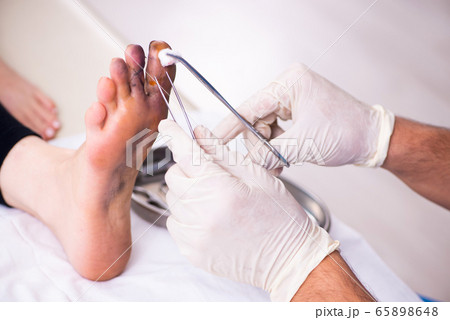 Finger injured woman visiting male doctor traumatologist 65898648