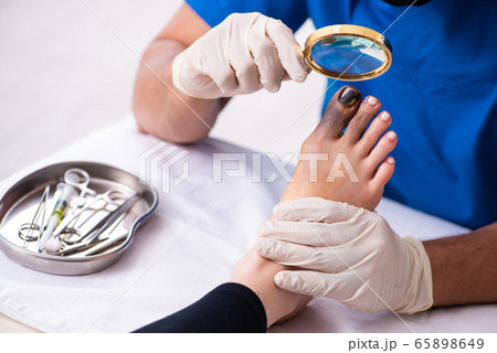 Finger injured woman visiting male doctor traumatologist 65898649