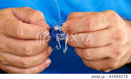 Man unraveling to the tangled and knotted Fishing 65899278