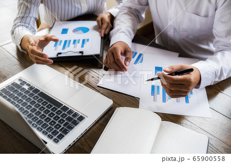 Business team brainstorming and discussing with financial data and report graph. 65900558