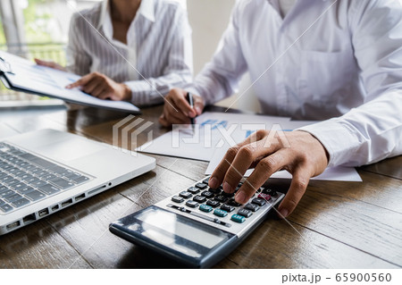 Business team brainstorming and discussing with financial data and report graph. Business team brainstorming and discussing with financial data and report graph. 65900560