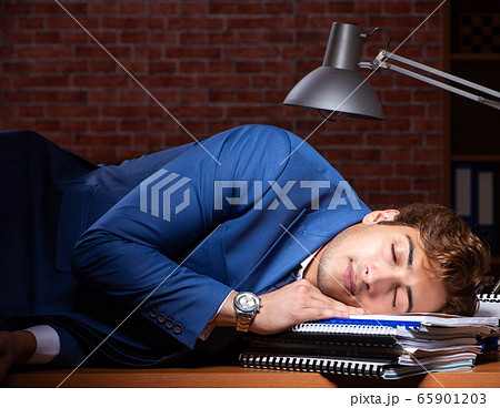 Young businessman working in the office at night 65901203