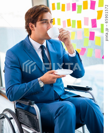 Young handsome man in wheelchair with many conflicting prioritie Young handsome man in wheelchair with many conflicting prioritie 65901572