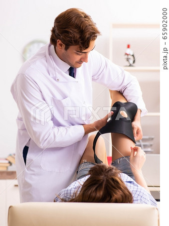 Young female patient visiting male doctor traumatologist Young female patient visiting male doctor traumatologist 65902000