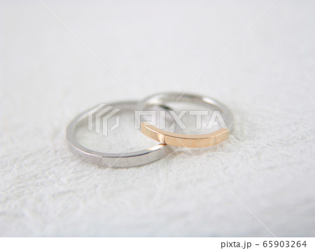 白い和紙の背景の ハンマリングデザインの結婚指輪の写真素材