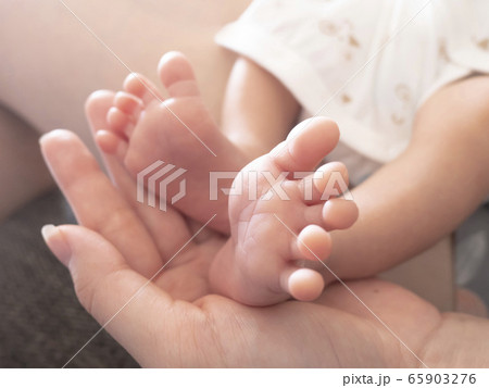 新生児の赤ちゃんが母の手のひらに足を乗せる愛らしいボディパーツ 新生児の赤ちゃんが母の手のひらに足を乗せる愛らしいボディパーツ 65903276