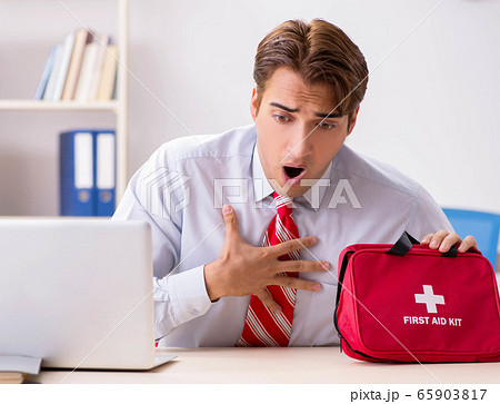 Man with first aid kit in the office 65903817