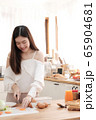 Cute woman slicing ham to prepare salad and sandwich for breakfast,vertical view. 65904681
