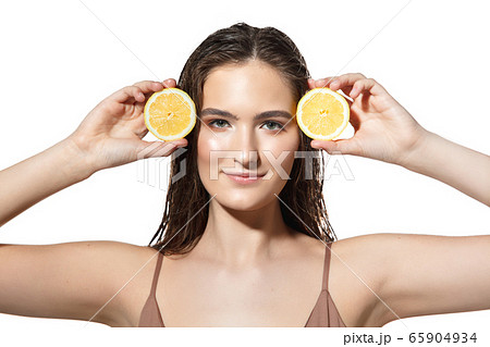 Citrus. Close up of beautiful female face with lemon slices over white background. Cosmetics and makeup, natural and eco treatment, skin care. Citrus. Close up of beautiful female face with lemon slices over white background. Cosmetics and makeup, natural and eco treatment, skin care. 65904934