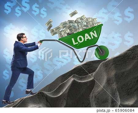 Businessman pushing wheelbarrow uphill in debt loan concept 65906084
