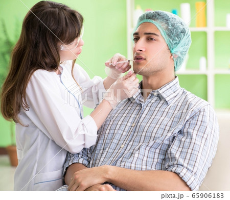 Plastic surgeon preparing for operation on man face 65906183