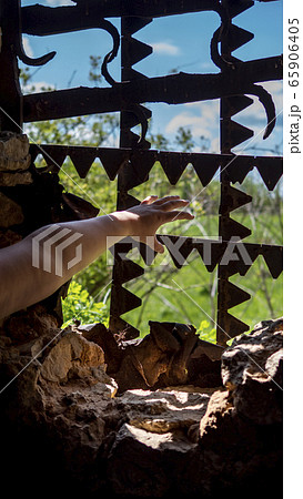 Hands reach for the metal bars in the window. Outside the window, the landscape was beautiful. Hands reach for the metal bars in the window. Outside the window, the landscape was beautiful. 65906405