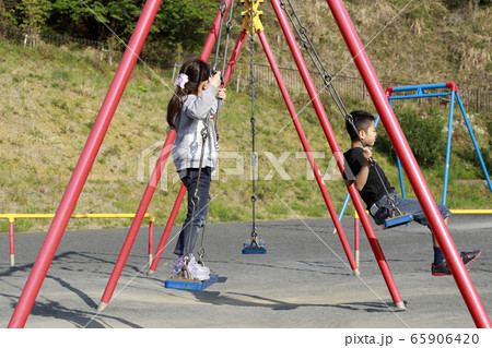 ブランコで遊ぶ兄妹(10歳と5歳) 65906420