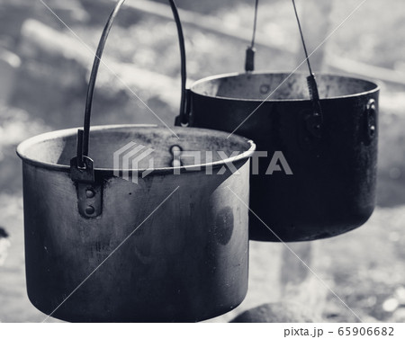 Cooking in two sooty old cauldrons on campfire at 65906682
