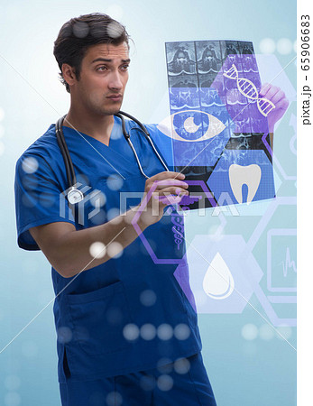 Young doctor looking at x-ray image in mhealth concept 65906683