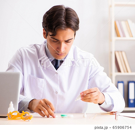 Young handsome doctor ophthalmologist with contact lenses in hos 65906754