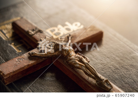 Closeup of wooden Christian cross on Bible. 65907240