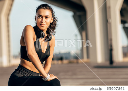 Beautiful fit woman stretching her legs before training Beautiful fit woman stretching her legs before training 65907861