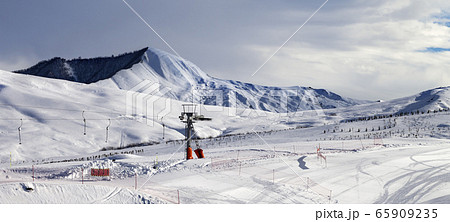 Ski slope with surface lift and gray sky Ski slope with surface lift and gray sky 65909235