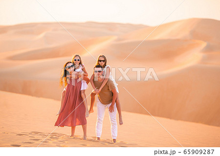 Girls among dunes in Rub al-Khali desert in United Arab Emirates 65909287