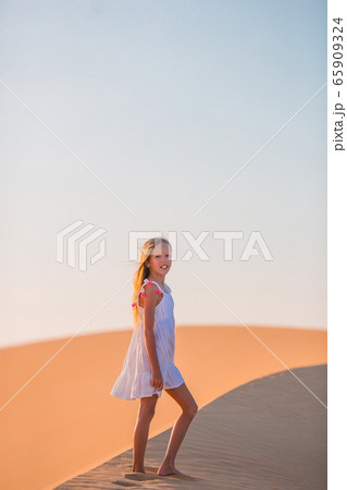 Girl among dunes in desert in United Arab Emirates Girl among dunes in desert in United Arab Emirates 65909324