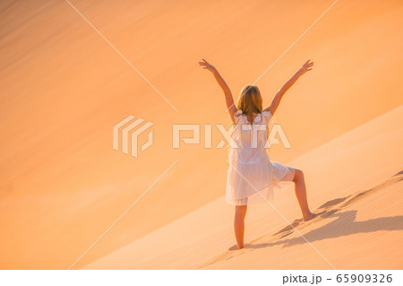 Girl among dunes in desert in United Arab Emirates 65909326