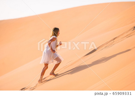 Girl among dunes in desert in United Arab Emirates 65909331
